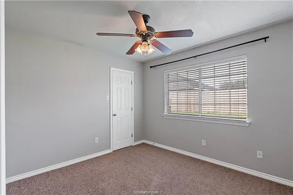 a view of an empty room with a ceiling fan and a window