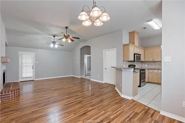 a view of a kitchen with a sink dishwasher a kitchen island with wooden floor
