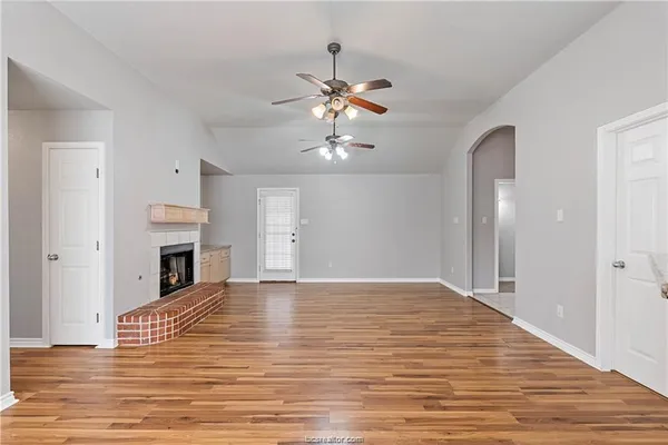 a view of a livingroom with a fireplace chandelier fan and windows