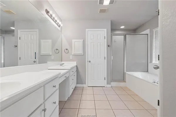a spacious bathroom with a granite countertop sink a toilet a mirror and shower