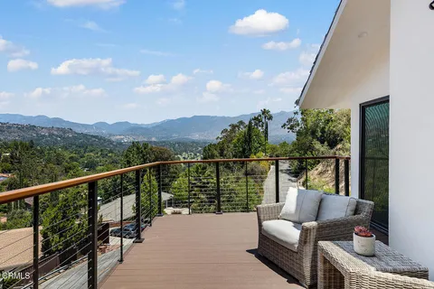 a balcony with wooden floor and outdoor seating