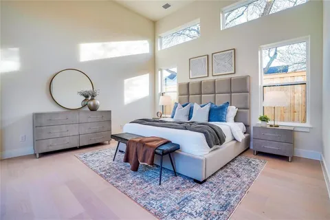 a bedroom with a bed a dresser and next to a window