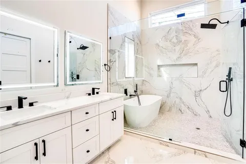 a bathroom with a double vanity sink mirror and shower
