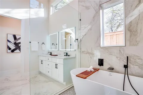a bathroom with a tub sink and mirror