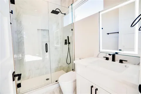 a bathroom with a bathtub shower sink and toilet