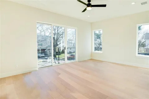 an empty room with windows and view of wooden floor