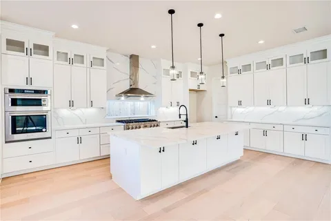 a large white kitchen with cabinets