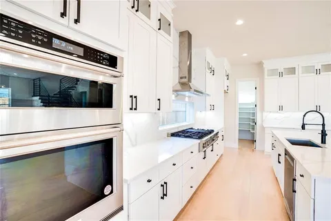 a kitchen with stainless steel appliances kitchen island granite countertop a stove a sink and a refrigerator