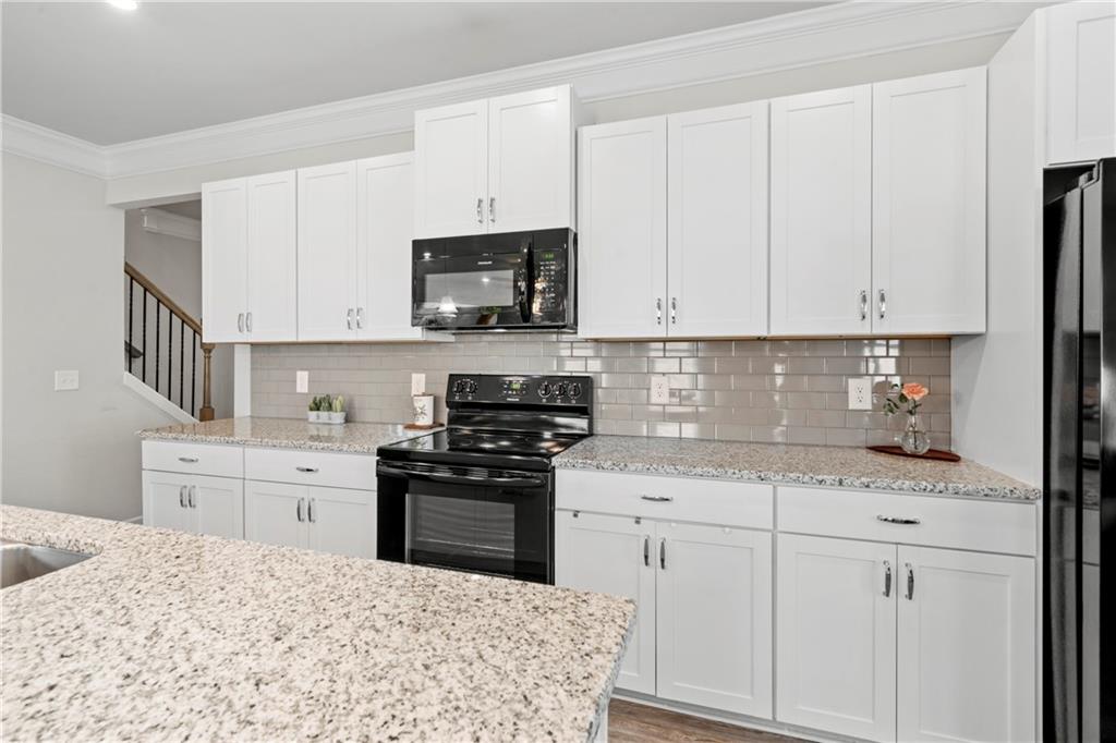 103 Waterside Drive Calhoun, GA 30701 - Photo 13 of 48 a kitchen with stainless steel appliances granite countertop a stove a sink and white cabinets