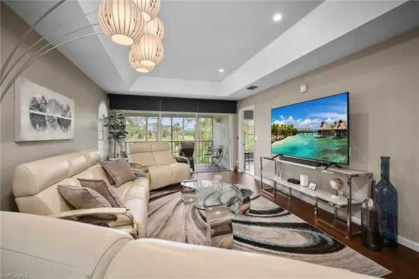 a living room with furniture a large window and a flat screen tv