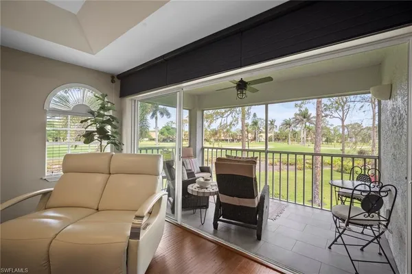 a living room with furniture and a floor to ceiling window