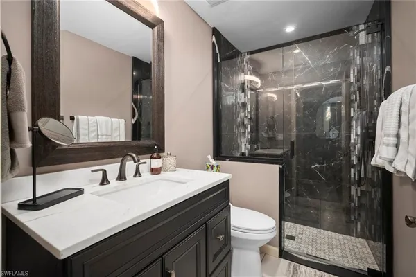 a bathroom with a sink shower and a mirror