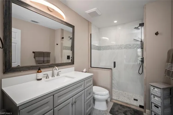 a bathroom with a sink toilet a mirror and shower