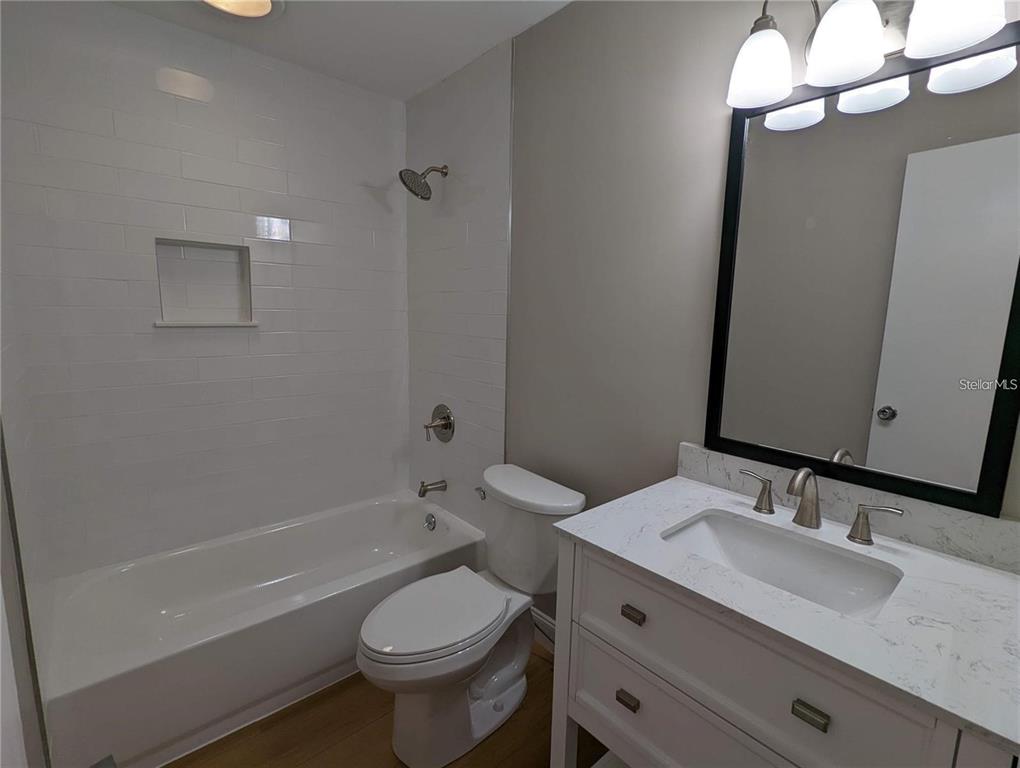 1922 Springtime Avenue Clearwater, FL 33755 - Photo 14 of 27 a bathroom with a granite countertop toilet a sink and a mirror