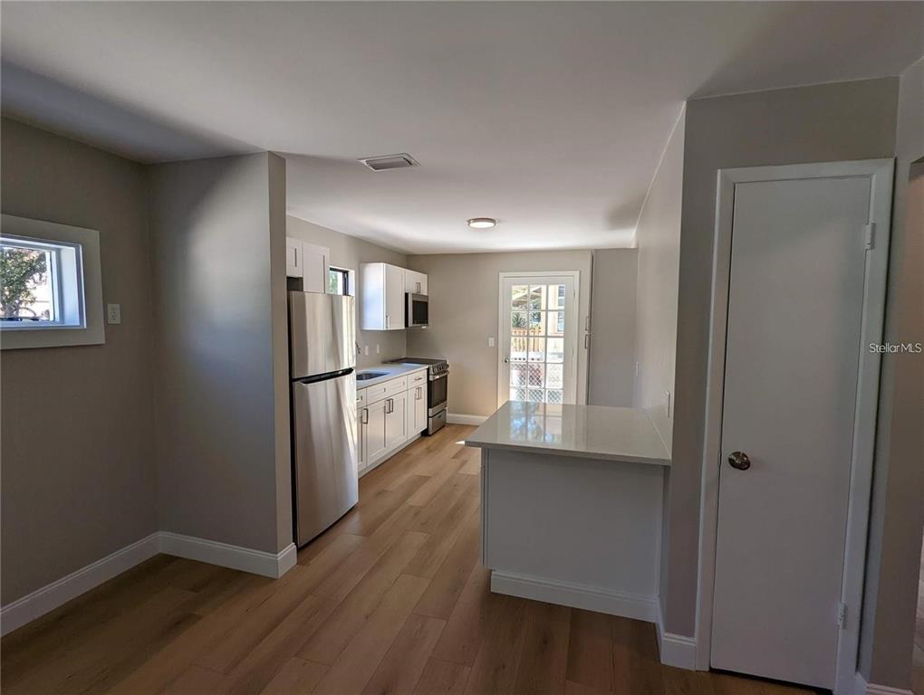 1922 Springtime Avenue Clearwater, FL 33755 - Photo 6 of 27 an empty room with wooden floor kitchen view and windows