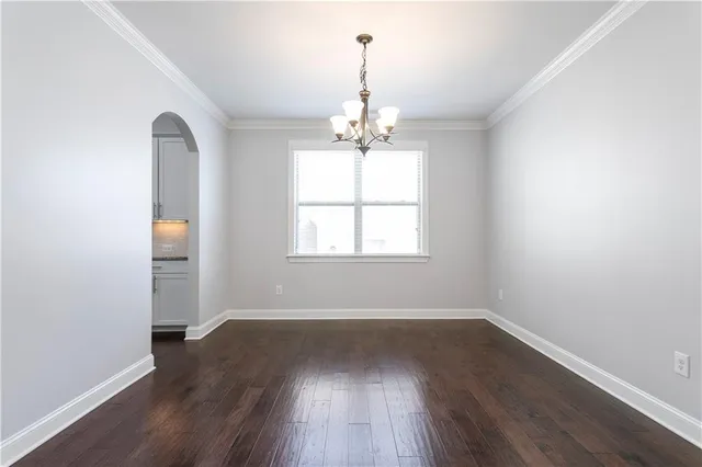 an empty room with wooden floor windows and entrance