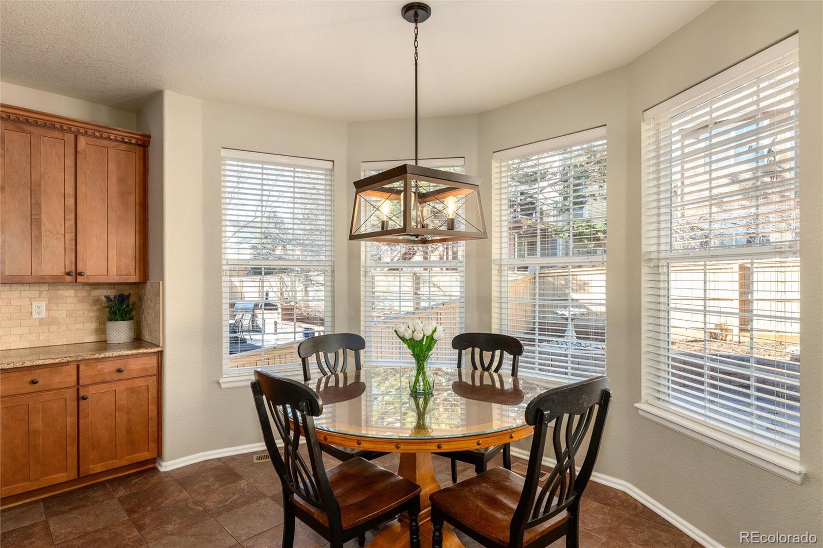 10820 Montvale Circle Highlands Ranch, CO 80130 - Photo 12 of 50 a dining room with furniture a chandelier and wooden floor