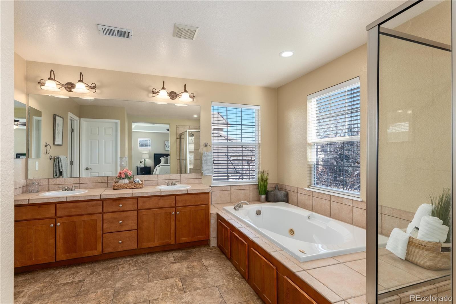 10820 Montvale Circle Highlands Ranch, CO 80130 - Photo 21 of 50 a bathroom with a tub a double vanity sink and mirror