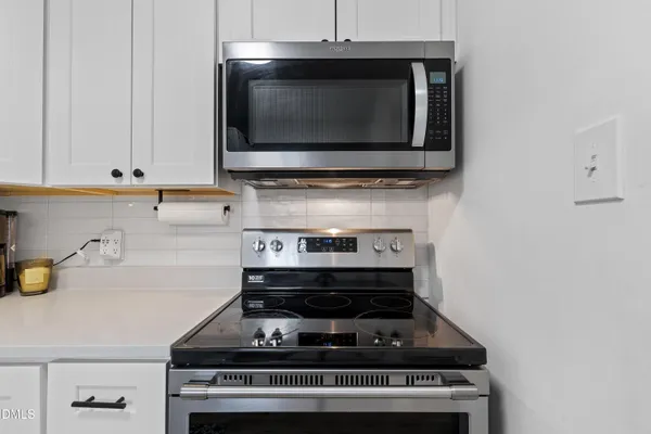 a stove top oven sitting inside of a kitchen