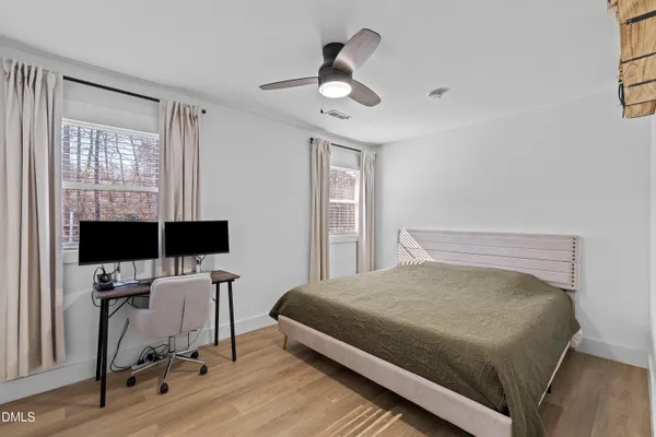 a bedroom with a bed and wooden floor