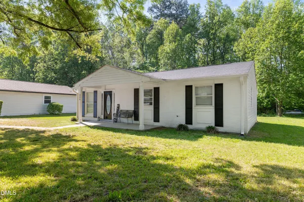 a view of a house with a yard and sitting area