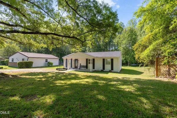 a front view of a house with a yard and trees