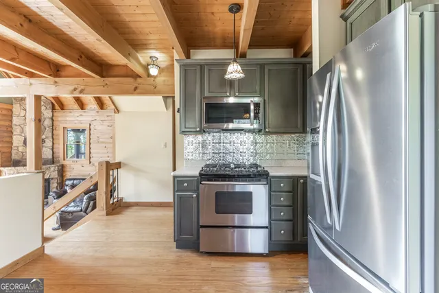 a kitchen with stainless steel appliances granite countertop a refrigerator and a stove