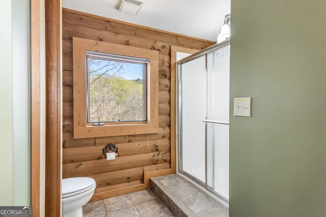 a bathroom with a toilet and a shower