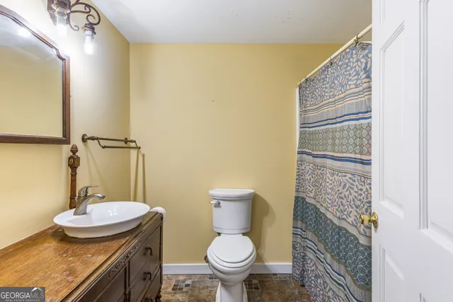 a bathroom with a sink a toilet and a mirror