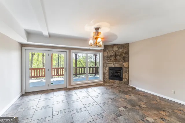 a view of an empty room with a fireplace and a window
