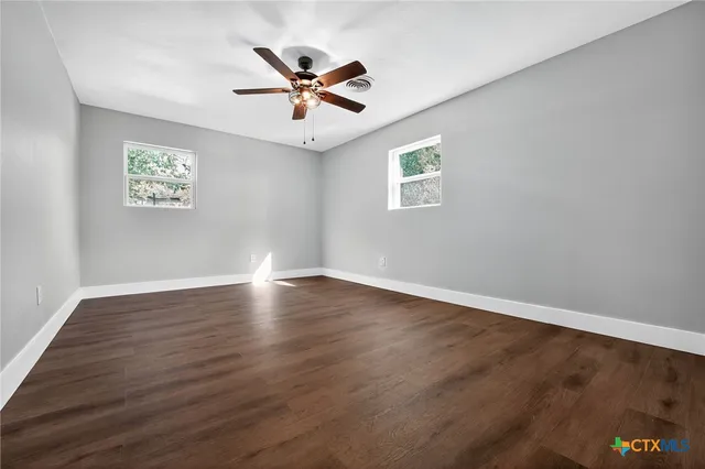 a view of empty room with wooden floor
