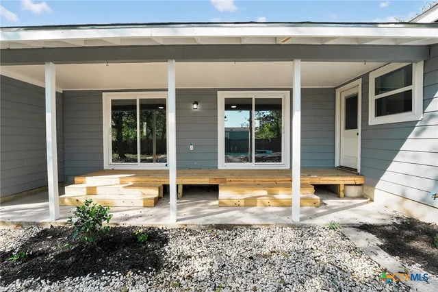 a view of a house with a large window and plants