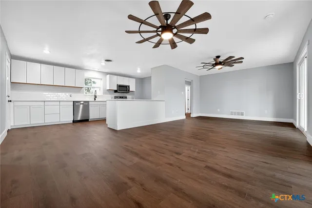 a view of a kitchen with a sink hardwood floor and a ceiling fan