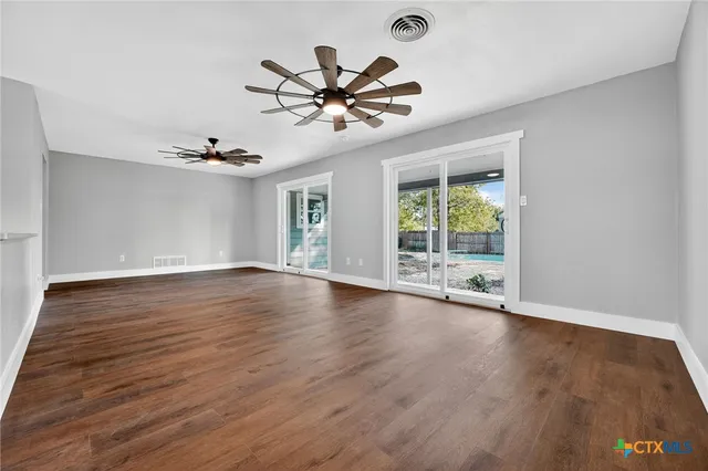 a view of a livingroom with wooden floor and a ceiling fan