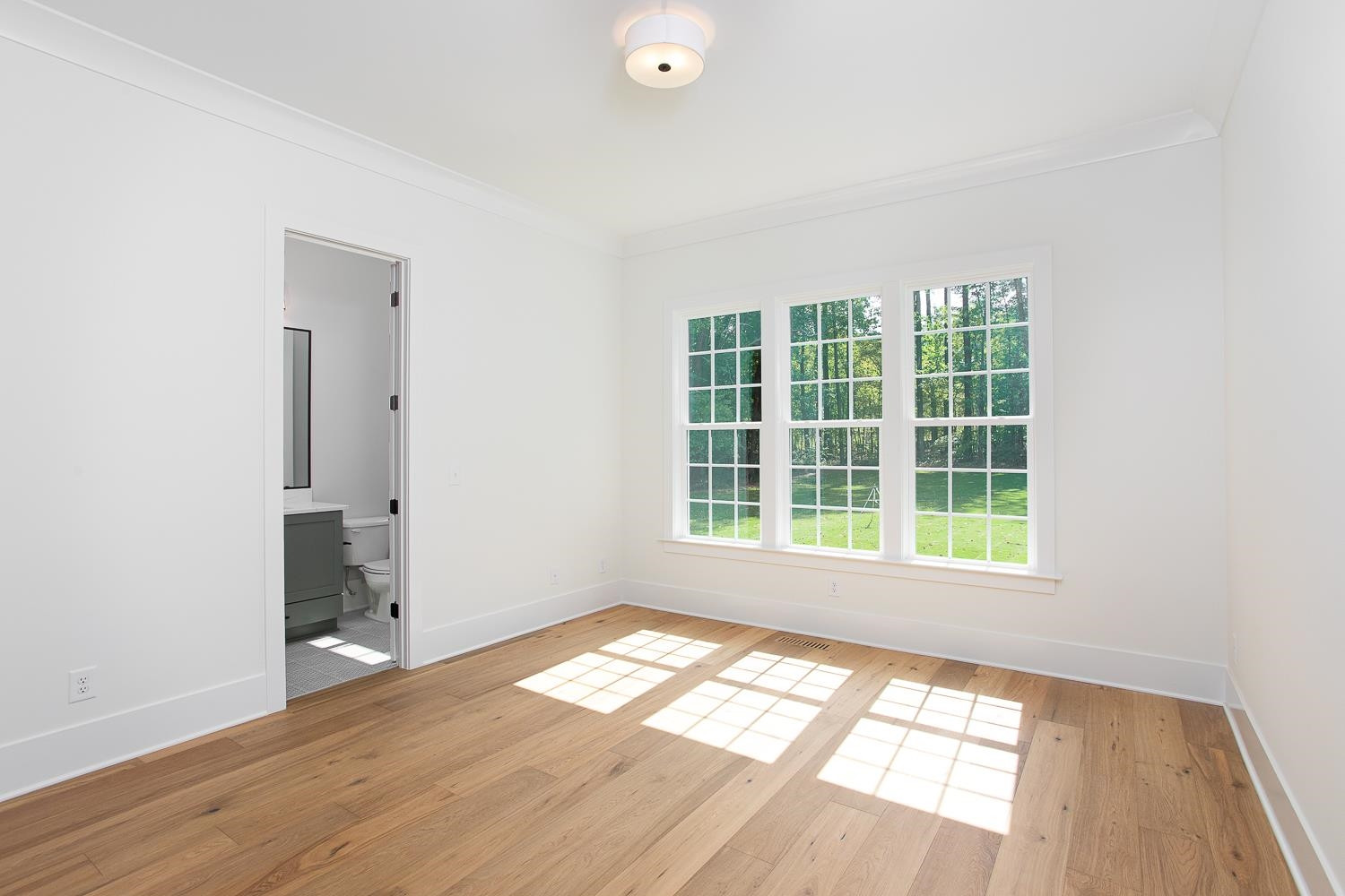 1417 Starry Night Court Raleigh, NC 27613 - Photo 22 of 44 an empty room with wooden floor and windows