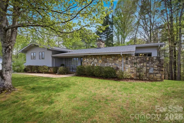 a view of a house with a yard and a tree