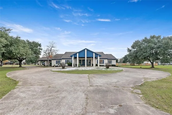 a view of a house with a yard and large trees