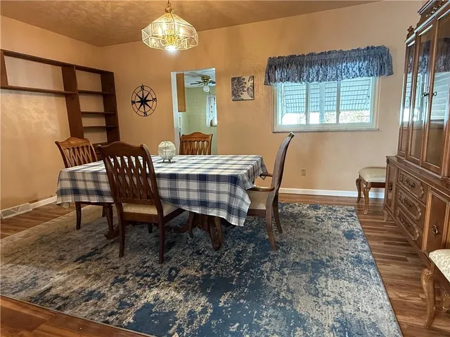 a view of a dining room with furniture a chandelier and wooden floor