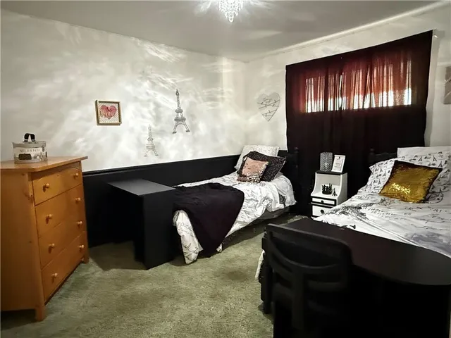 a bed sitting in a bedroom next to a window