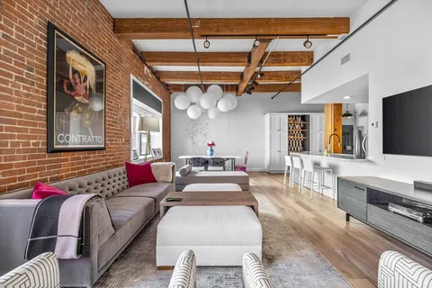 a living room with furniture flat screen tv and window
