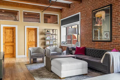 a living room with furniture a flat screen tv and a floor to ceiling window