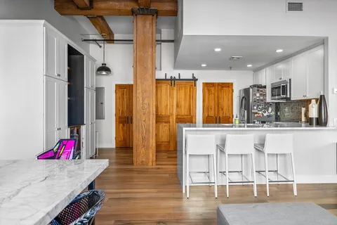 a kitchen with granite countertop a refrigerator and wooden cabinets