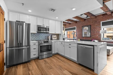a kitchen with granite countertop stainless steel appliances and wooden cabinets