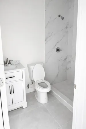 a white toilet sitting next to a bathroom sink