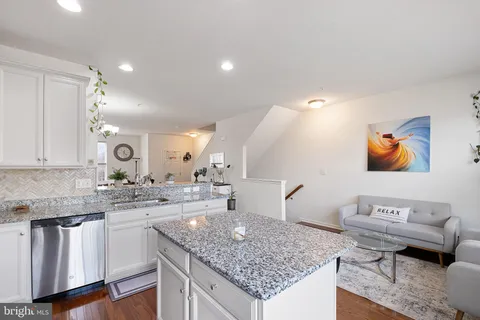 a kitchen with stainless steel appliances granite countertop a sink stove and cabinets