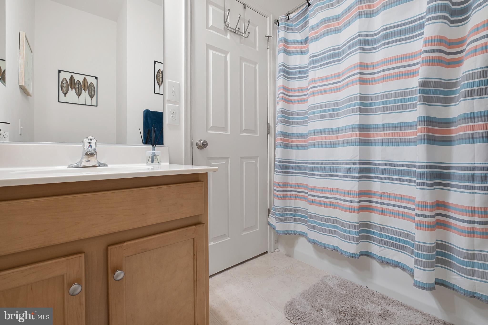 453 Lenape Way Claymont, DE 19703 - Photo 18 of 20 a bathroom with a sink a mirror and shower curtain