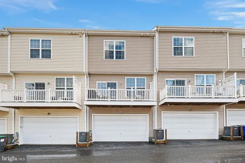 a front view of residential houses with parking