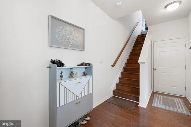 a view of a hallway with entryway and wooden floor