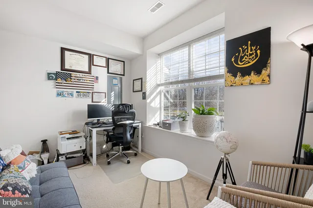 a view of a workspace with furniture and a window