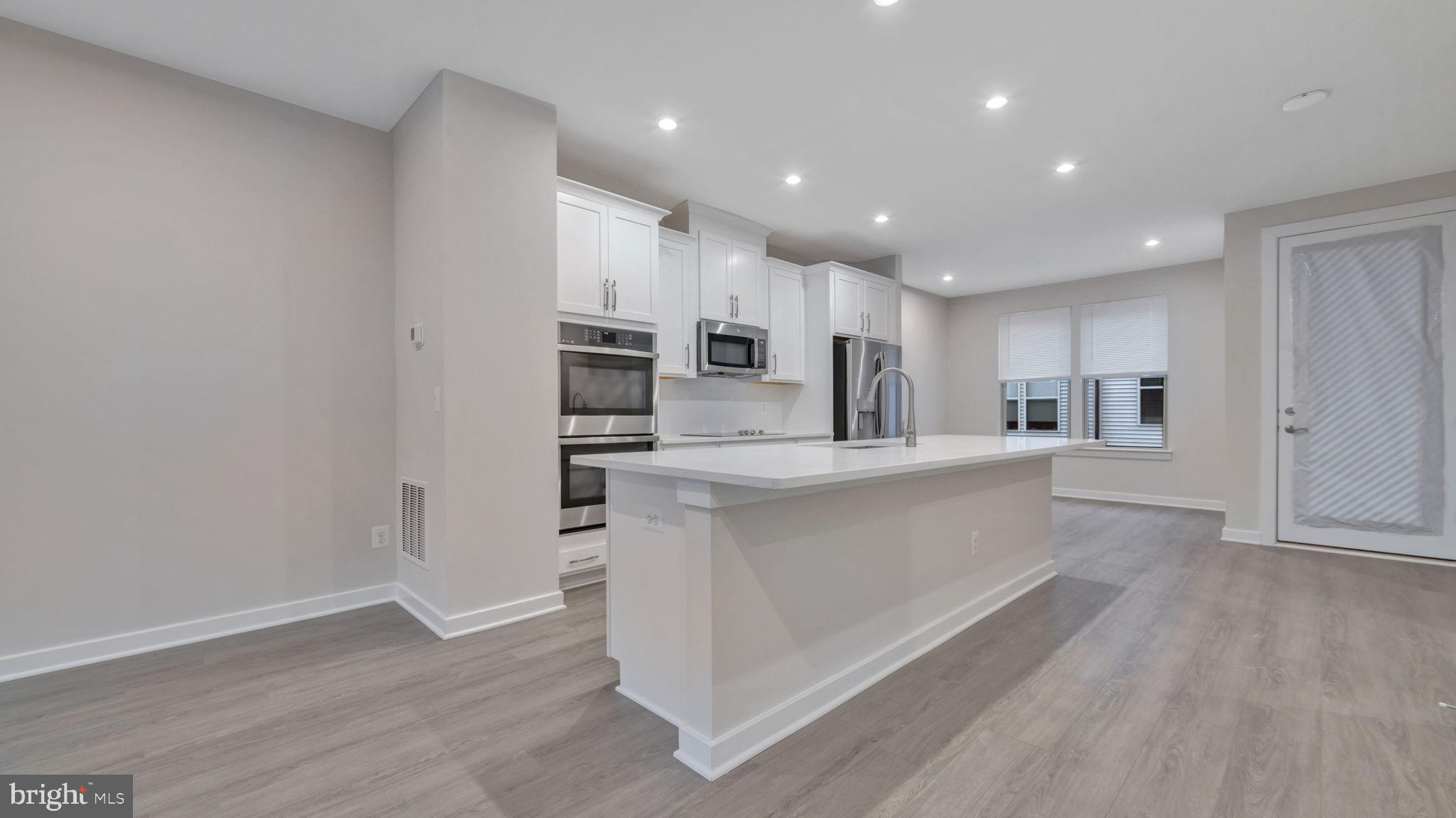13170 Arches Road Herndon, VA 20170 - Photo 16 of 30 a large kitchen with a center island wooden floor and stainless steel appliances